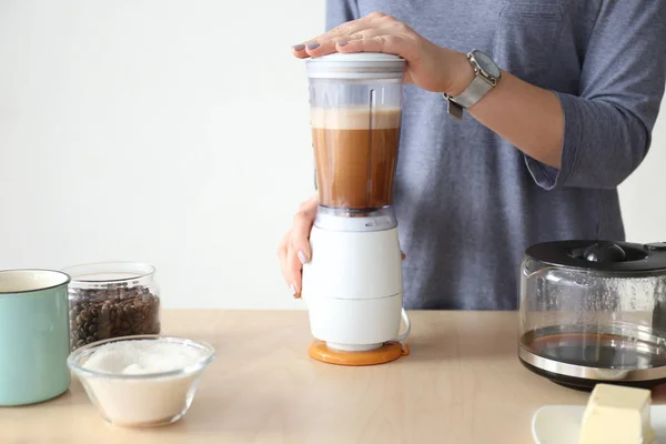 Wanita menggunakan blender untuk membuat kopi — Stok Foto