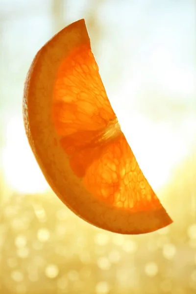 Plasterek pomarańczy na niewyraźne tło — Zdjęcie stockowe