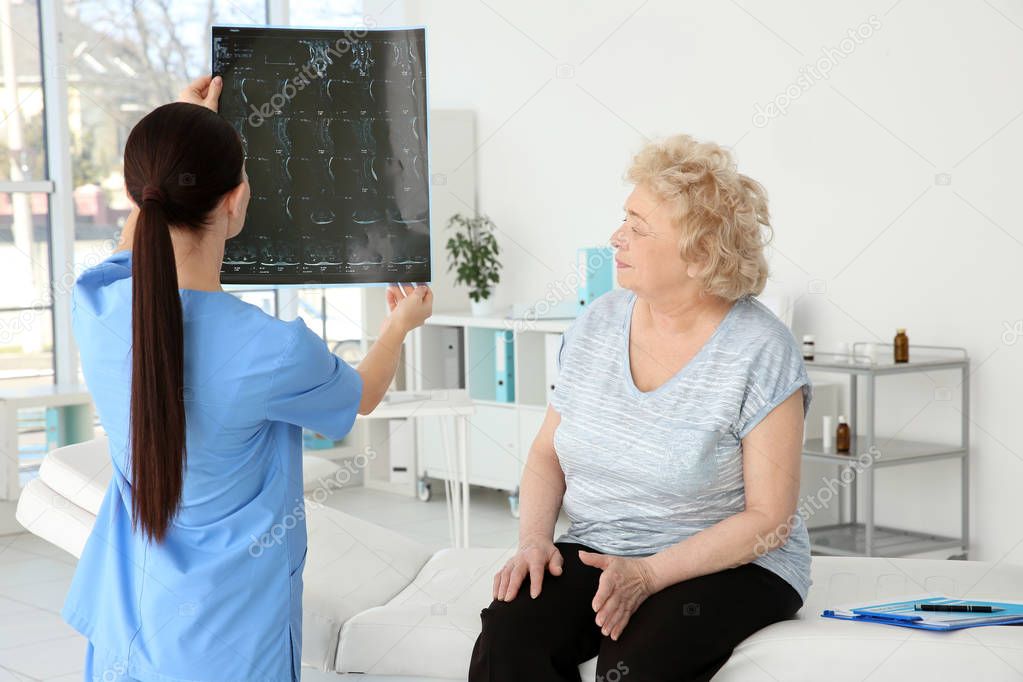 orthopedist examining senior woman 