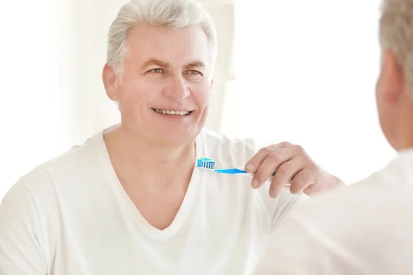 Senior uomo pulizia dei denti — Foto Stock