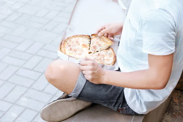 Человек с пиццей на улице — стоковое фото
