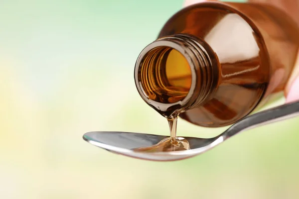 Pouring cough syrup into spoon — Stock Photo, Image