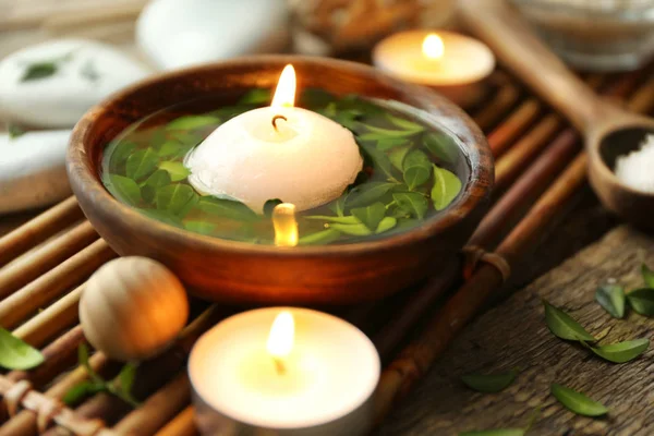 Miska z wodą, zielone liście i palenie świec — Zdjęcie stockowe