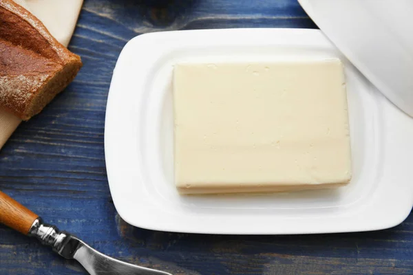 Schüssel mit Butter auf Holztisch — Stockfoto