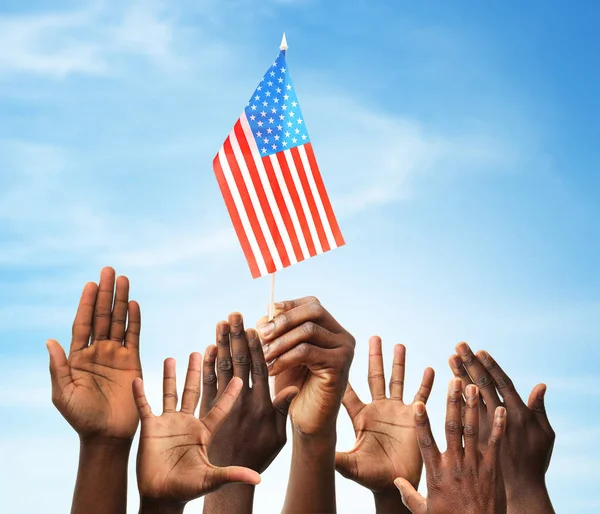 People raising hands and American flag