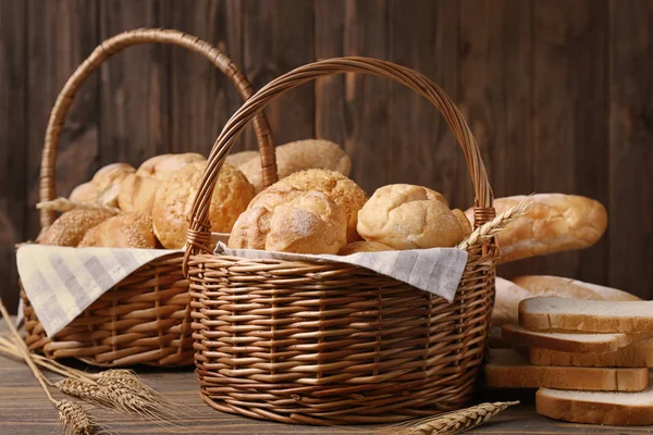 Baskets with different bread on wooden background — Stock Photo, Image