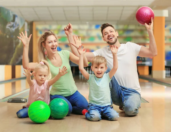 Szczęśliwa rodzina siedzi na podłodze w bowling club — Zdjęcie stockowe