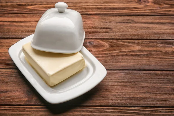 Miska s máslem na dřevěný stůl — Stock fotografie