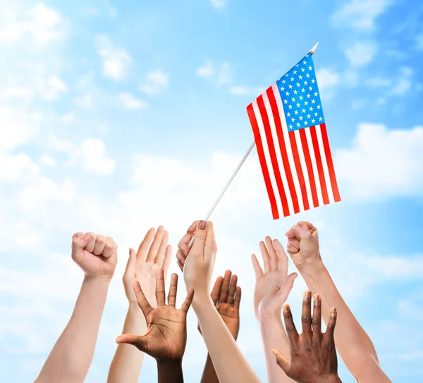 People raising hands and American flag