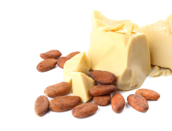 Kawałki masła kakaowego i fasoli na białym tle — Zdjęcie stockowe