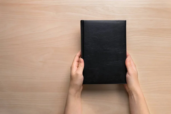 Manos femeninas sosteniendo libro cerrado —  Fotos de Stock