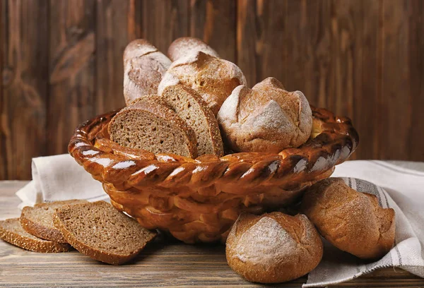 Pieczone kosz z chleba żytniego na podłoże drewniane — Zdjęcie stockowe