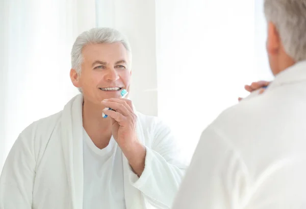 Senior uomo pulizia dei denti — Foto Stock