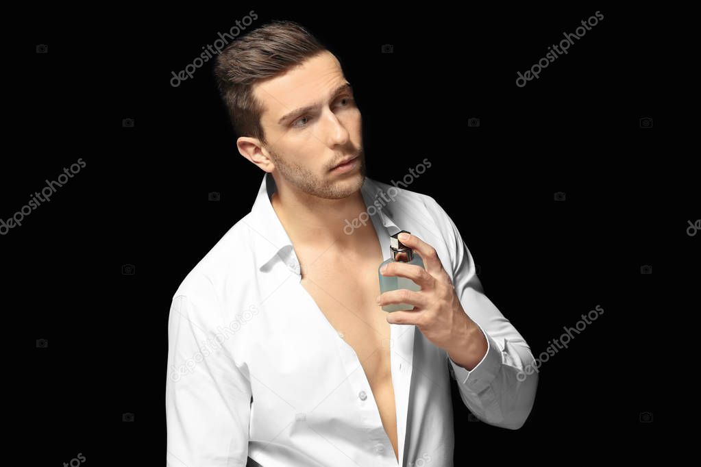 Handsome man using perfume 