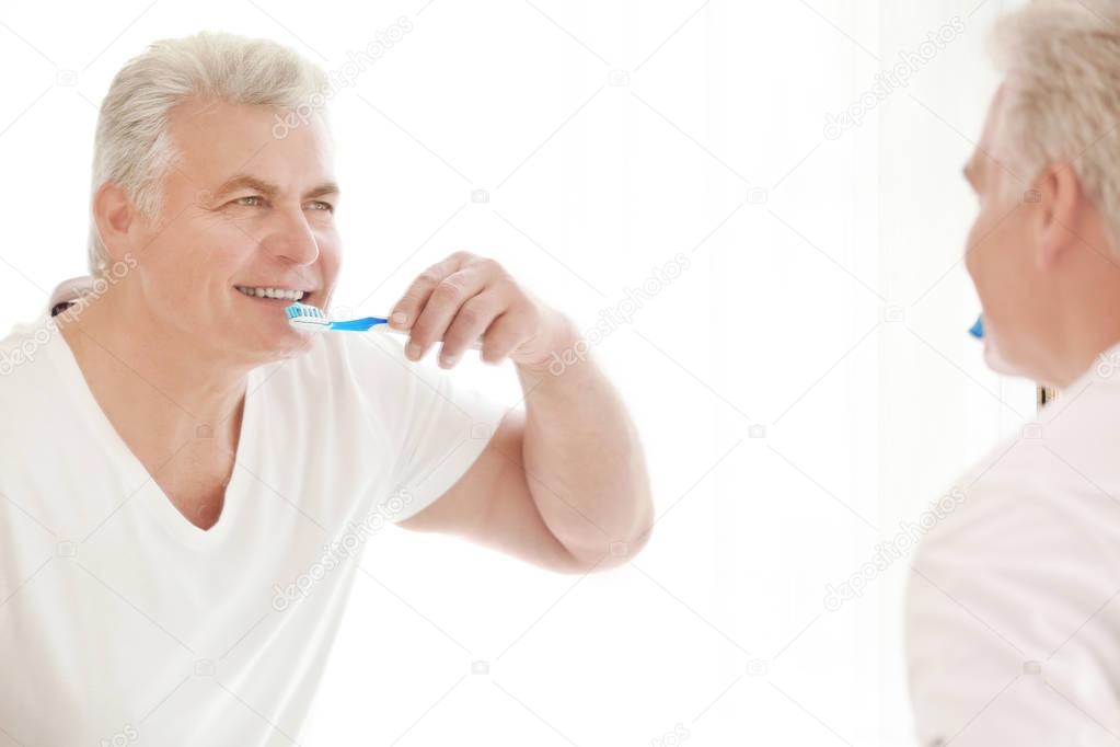 Senior man cleaning teeth  