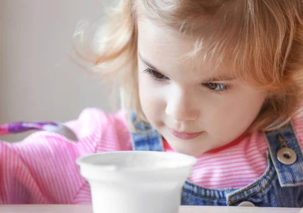 Niña comiendo yogur — Foto de Stock