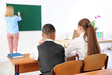 Öğrenciler sınıfta öğretmen dinlerken