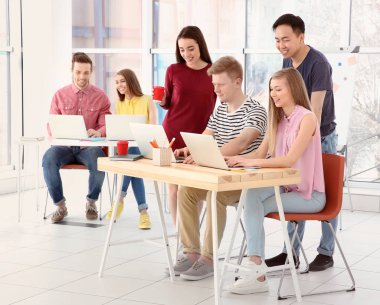 Genç insanlar ofiste dizüstü bilgisayarlar ile çalışma