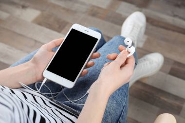 Kadın ile modern telefon ve kulaklık 