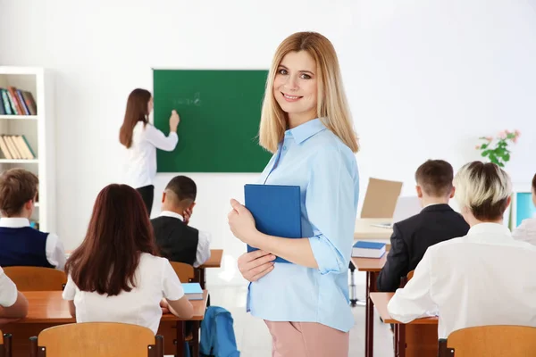 Vrouwelijke leraar met laptop in de klas — Stockfoto