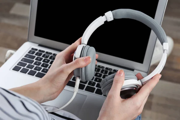 Mujer con portátil moderno y auriculares — Foto de Stock