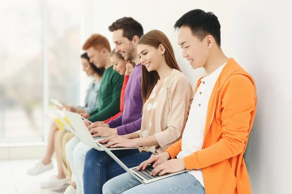 Jongeren met laptops zitten op stoelen — Stockfoto