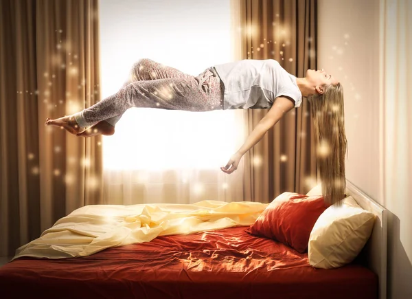 Spánkové paralýze koncept. Mladá žena, vznášející se nad postel — Stock fotografie