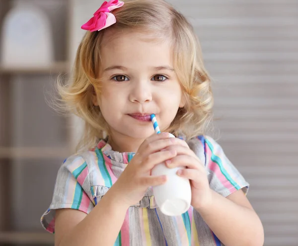 Маленька дівчинка п'є йогурт — стокове фото