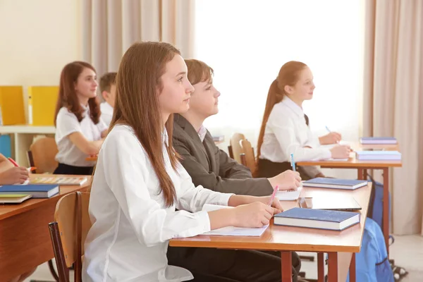 Eleverna sitter vid skrivbord i klassrummet — Stockfoto