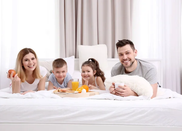 A család ágyban reggelizik — Stock Fotó