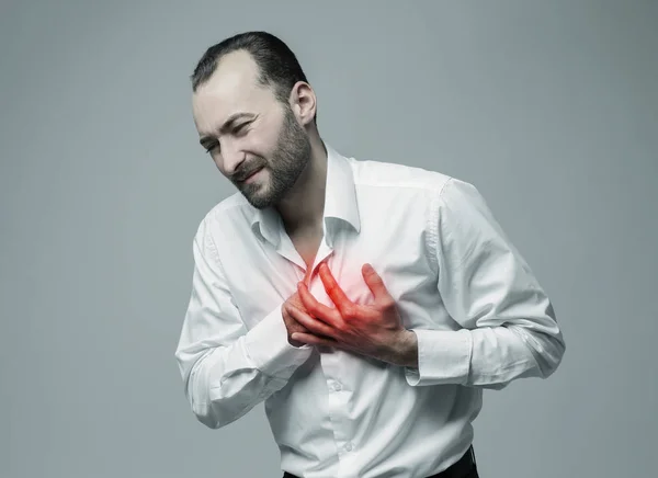Koncepcja atak serca. Człowiek cierpi na ból w klatce piersiowej na szarym tle — Zdjęcie stockowe