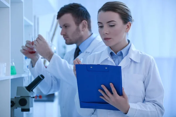 女性と男性の科学者が実験室での作業 — ストック写真