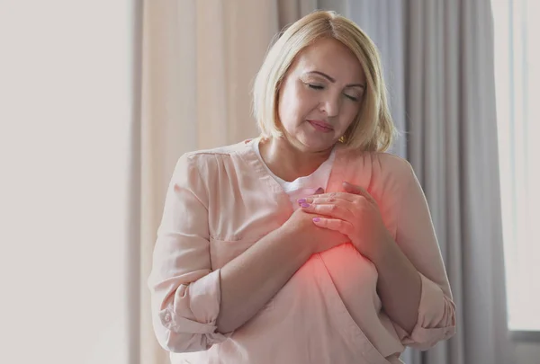 Concetto di infarto. Donna anziana che soffre di dolore toracico al coperto — Foto Stock