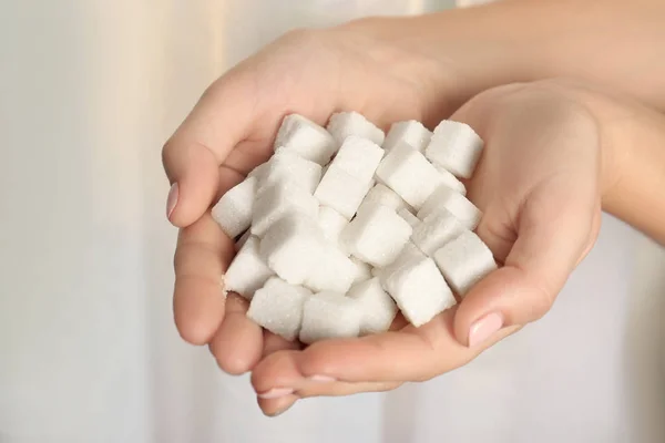 Mãos segurando cubos de açúcar — Fotografia de Stock