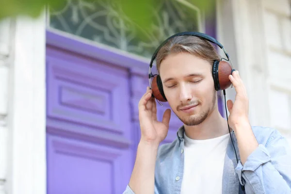 Bello giovane uomo che ascolta musica all'aperto — Foto Stock