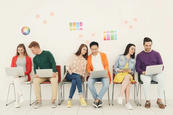 Jóvenes con aparatos sentados en sillas — Foto de Stock