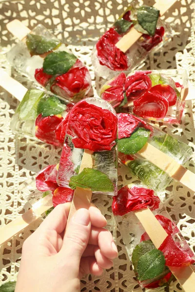 Hand holding popsicle with flowers — Stock Photo, Image