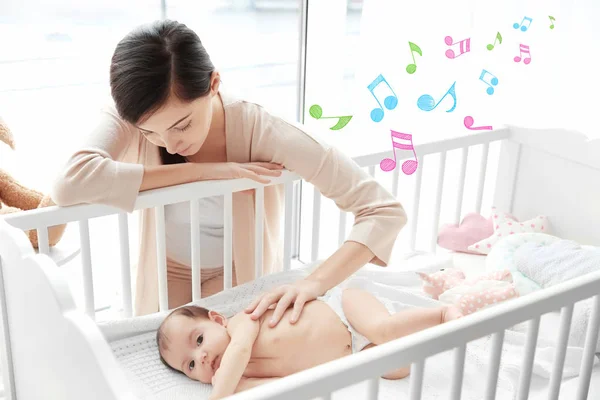 Anya baba bölcső fekve közelében. Altató dal és zene fogalma — Stock Fotó