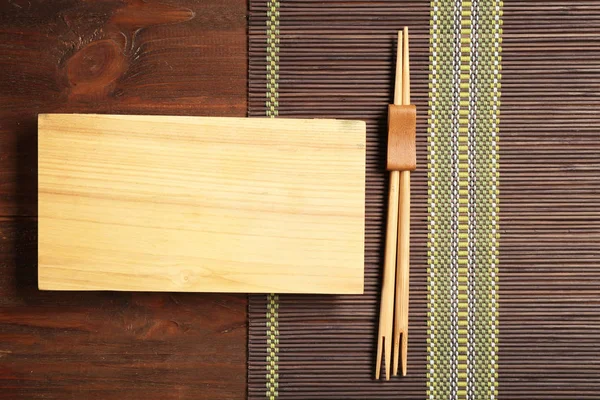 Прямоугольная деревянная тарелка и палочки для еды — стоковое фото
