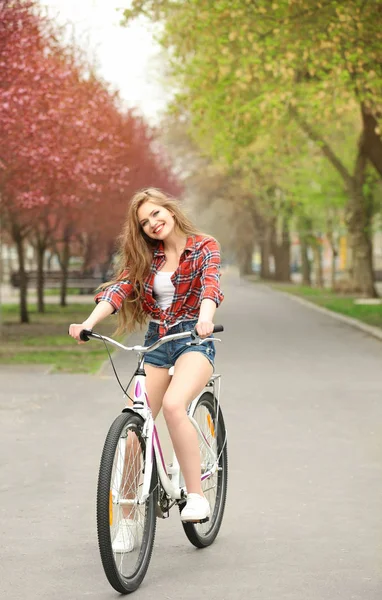 Молодая улыбающаяся женщина с велосипедом — стоковое фото