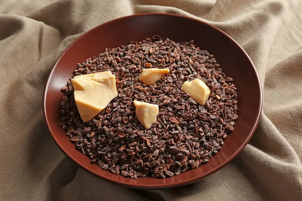 Bowl with cocoa nibs and butter — Stock Photo, Image