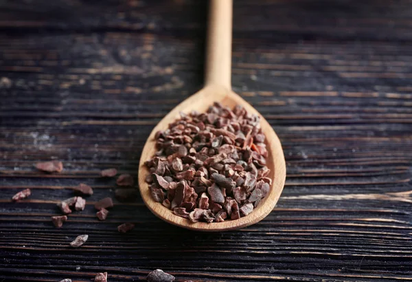 Wooden spoon with cocoa nibs — Stock Photo, Image