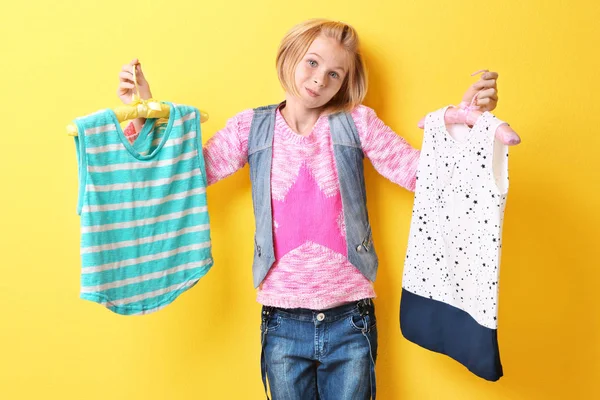 Niña sosteniendo perchas con ropa — Foto de Stock