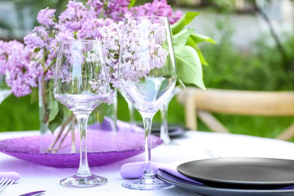 Tischdekoration mit fliederfarbenen Blumen — Stockfoto