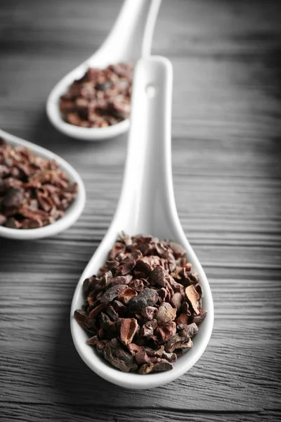 White spoons with cocoa nibs — Stock Photo, Image