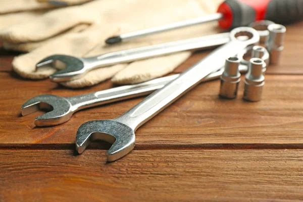 Setting of tools for car repair and gloves on wooden background — Stock Photo, Image