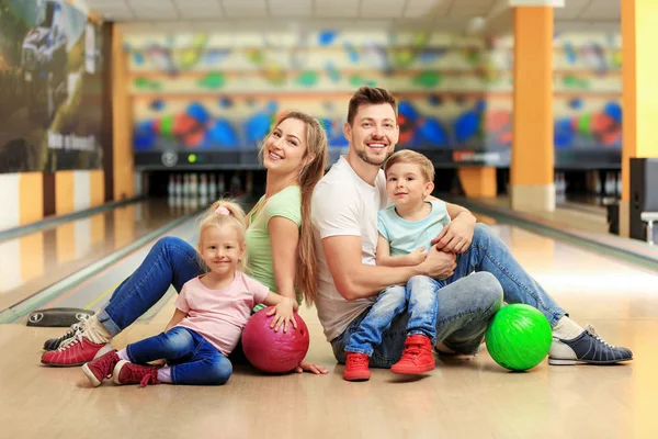 Happy family sitting on floor in bowling club Royalty Free Stock Images