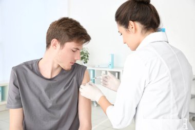 Genç adam kliniğinde tıbbi asistan enjeksiyon aldıktan