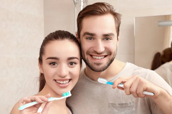 Pareja joven cepillándose los dientes — Foto de Stock