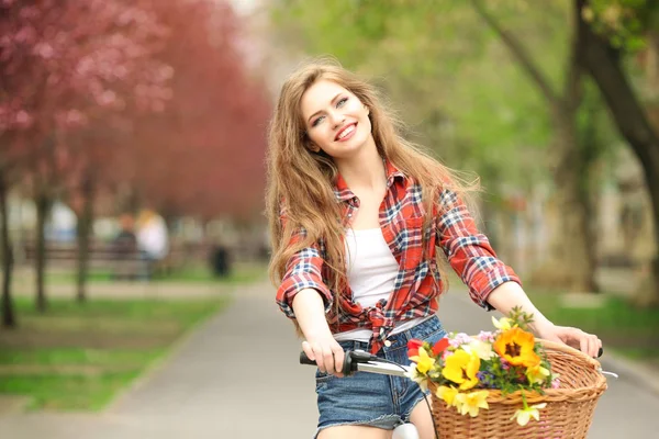 Unga leende kvinna med cykel — Stockfoto